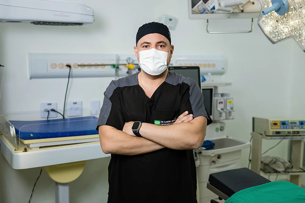 Dr. Gabriel Braga com máscara e vestimenta cirúrgica na sala de cirurgia, referência em videolaparoscopia em Pirapora